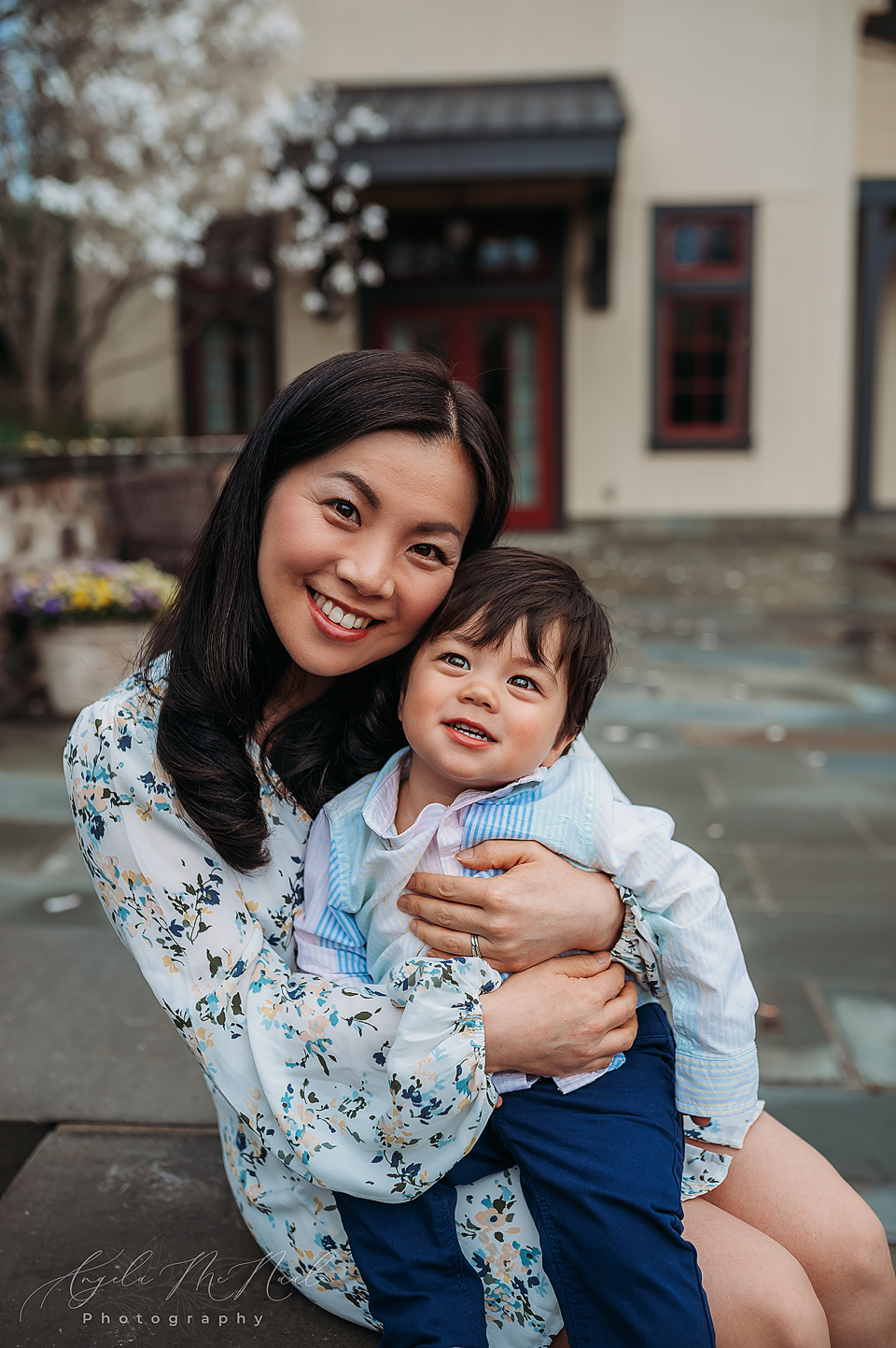 Smiling Asian Mother holding smiling little boy