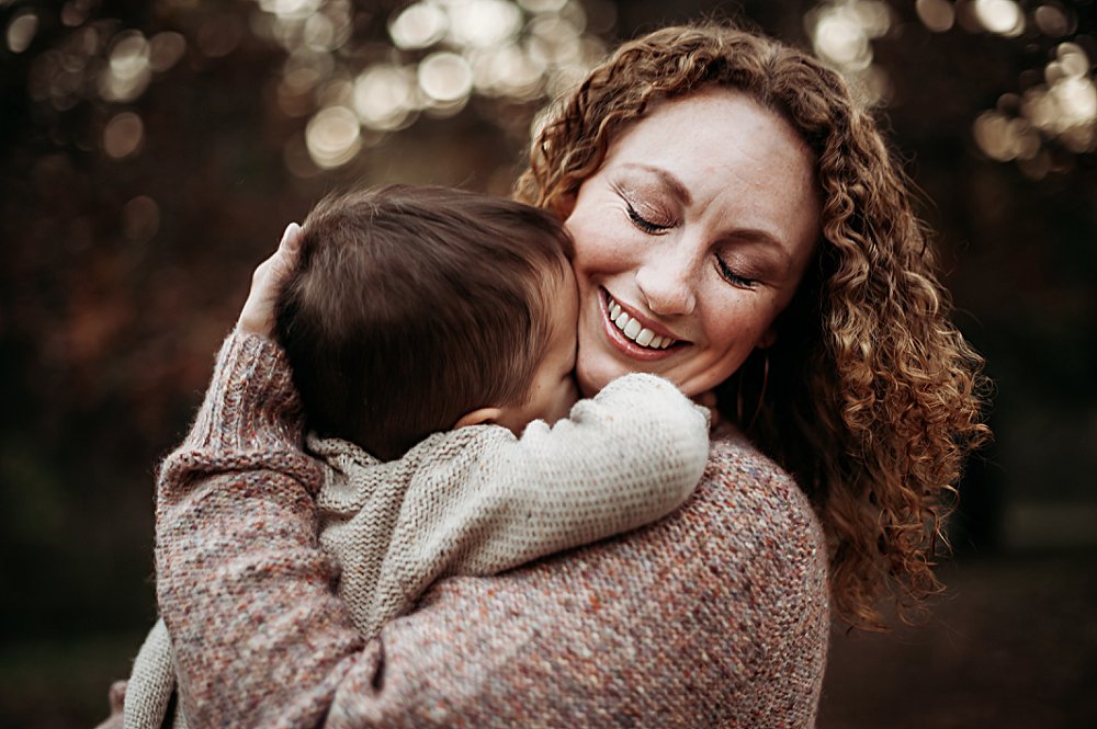 Mom hugging toddler son and smiling