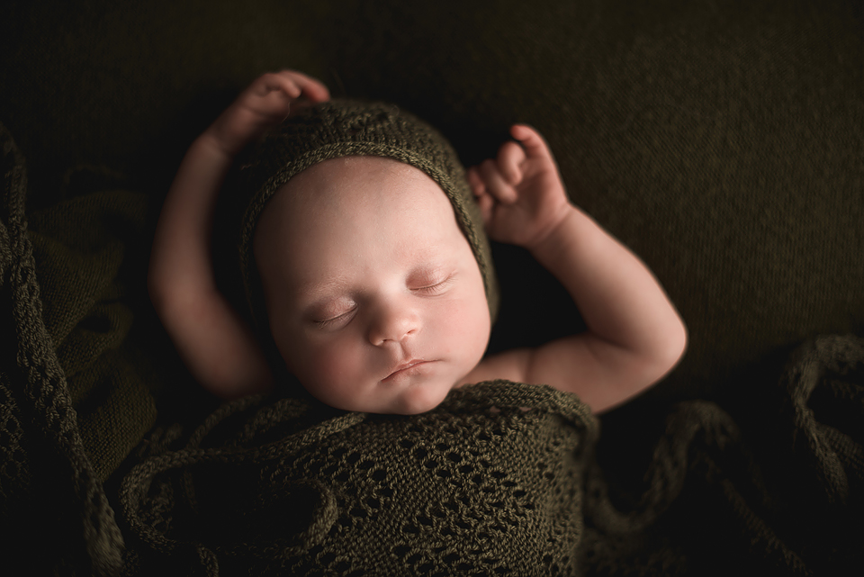 Newborn sleeping with bonnet and swaddle