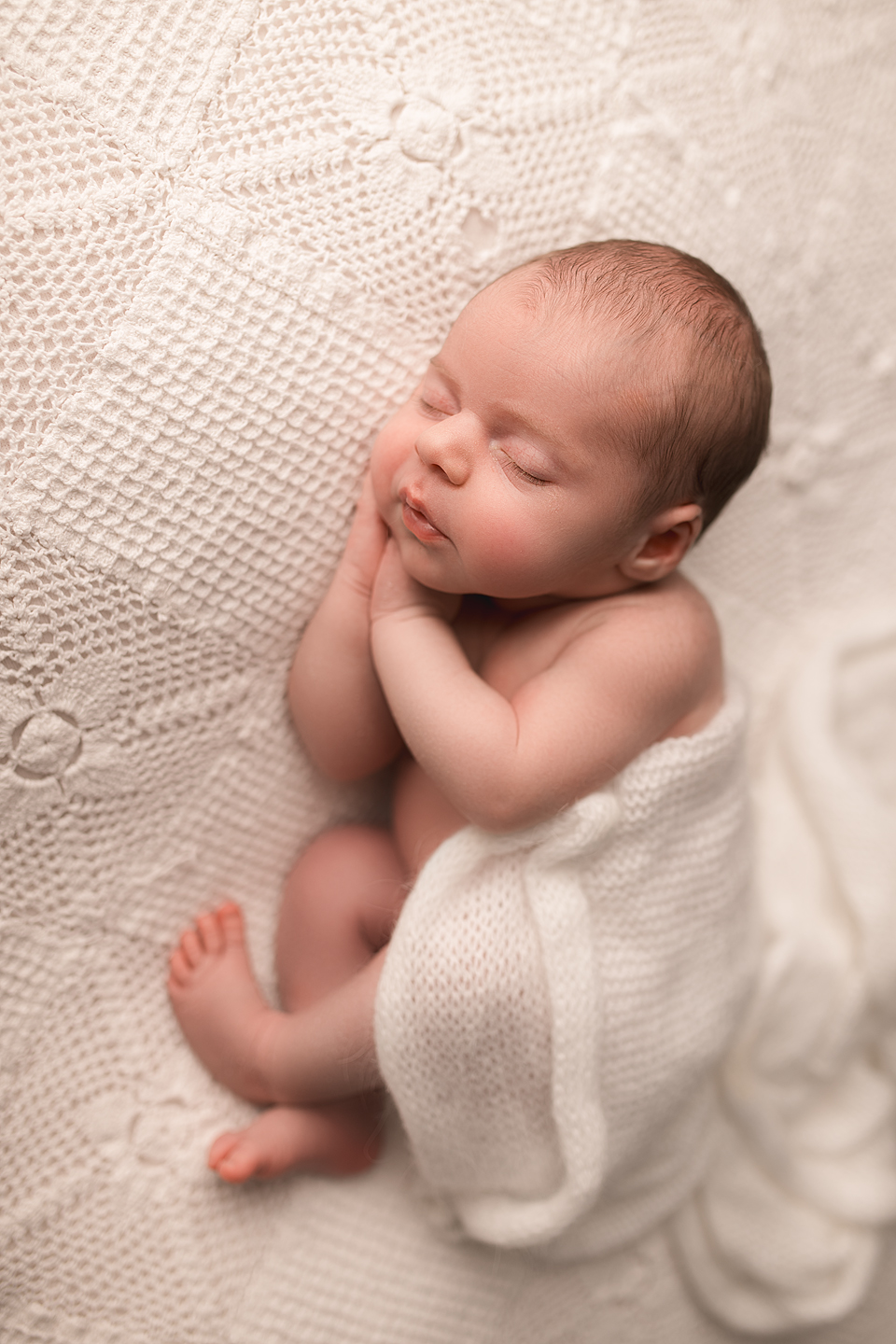 Charlottesville newborn photography of baby wrapped in soft white blanket in lace studio setup